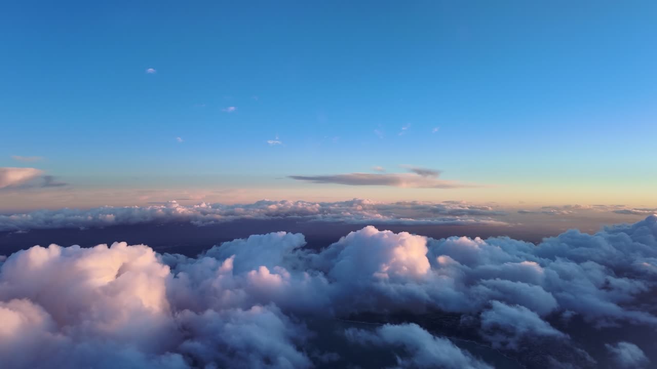 Peceful scene captured from a jet cockpit while flying over some broken golden clouds hanging over the Mediterranean Sea illuminated by the soft sunset light