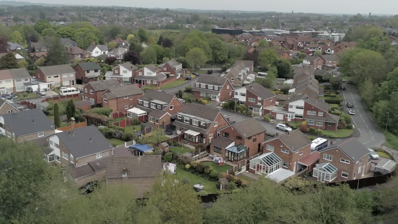 Stille britiske huse og haver i et beboelseskvarter i forstaden, luftfoto med langsom dolly til højre