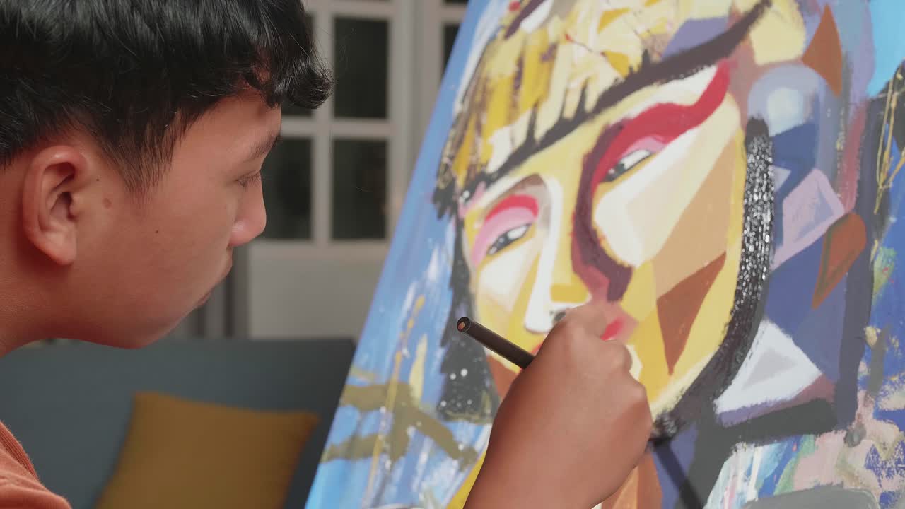 Close Up Side View Of An Asian Artist Boy Holding Paintbrush Mixed Colour And Painting A Girl'S Face On The Canvas