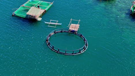 a group of fisherman's huts on stilts, over calm blue ocean water