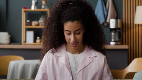 young woman opening a take-out food container at home