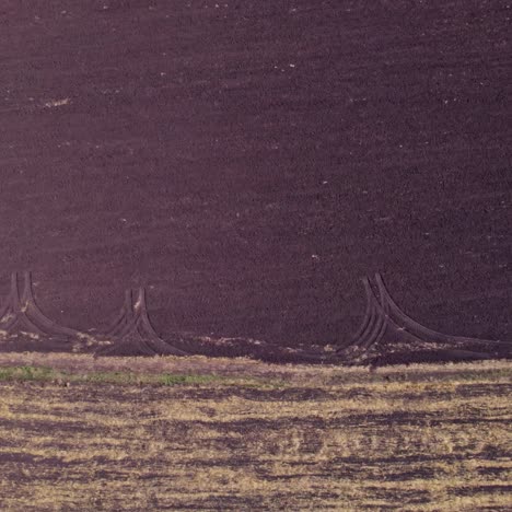 aerial view of tilled farmland with tire tracks