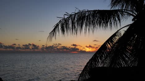 Long-shot-of-sunset-and-evening-sky-over-the-Lagoon-of-Fakarava,-French-Polynesia,-south-pacific-ocean-with-reflexions-on-the-calm-water-surface