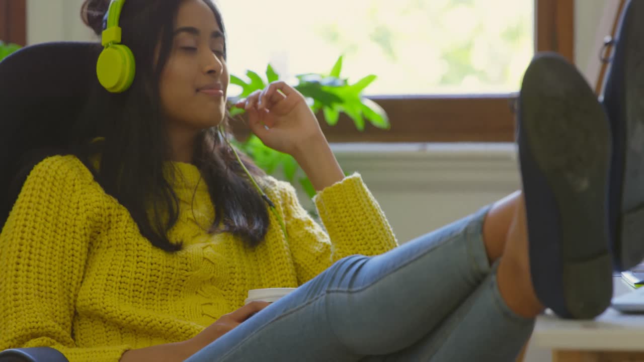 여성 그래픽 디자이너가 헤드폰 4k로 음악을 듣고 있습니다.