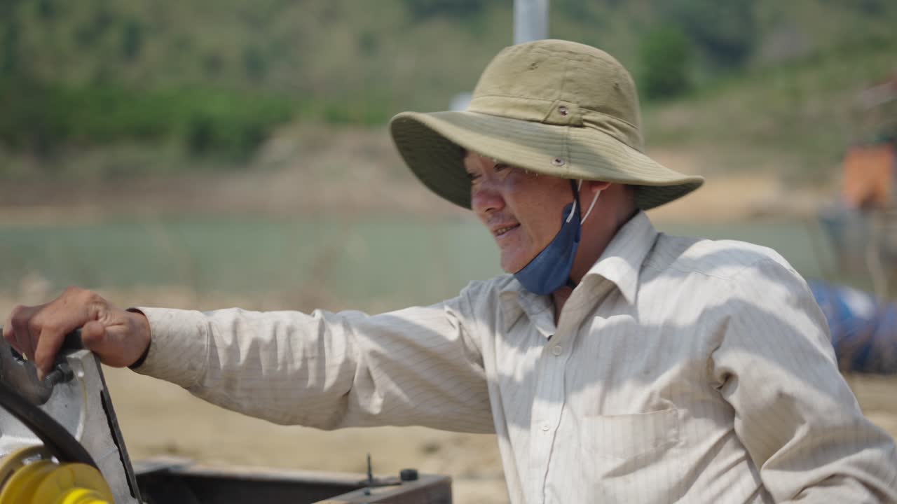 Worker repairing machinery near a body of water