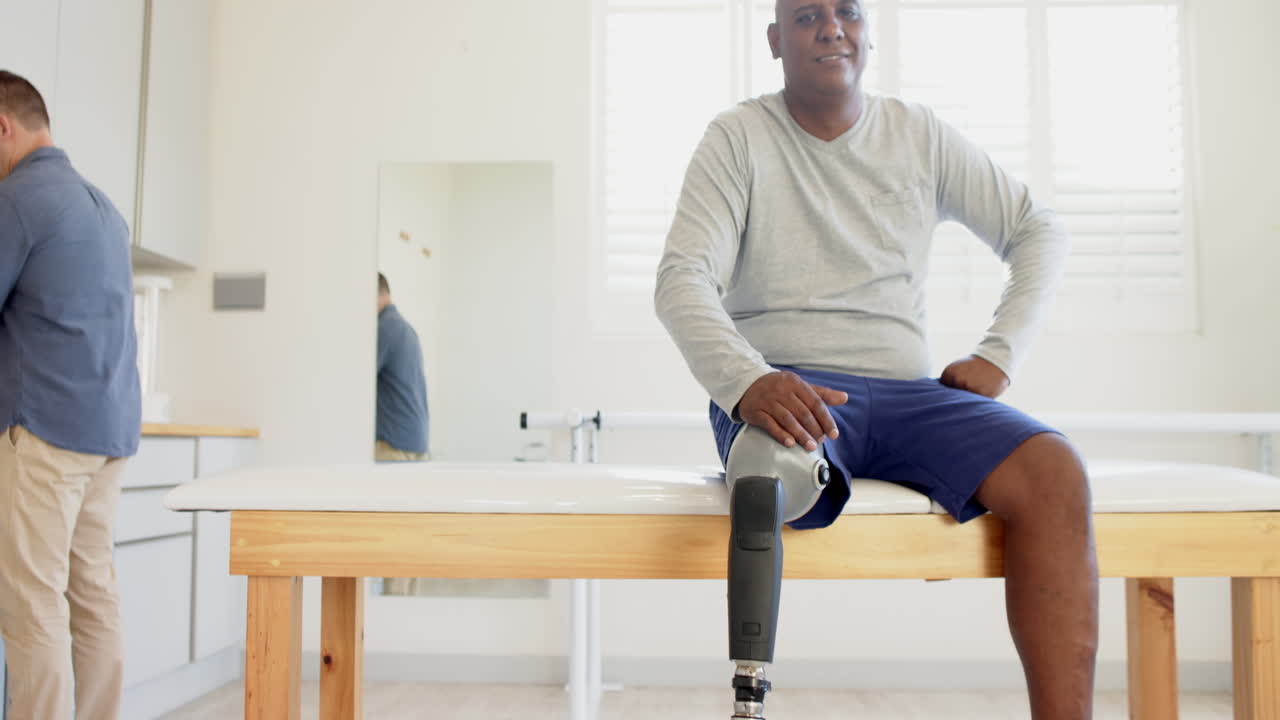 Sitting on examination table, man with prosthetic leg waiting in lab