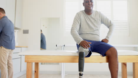 sitting on examination table, man with prosthetic leg waiting in lab