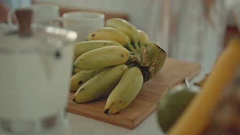 bunch of bananas on a wooden cutting board