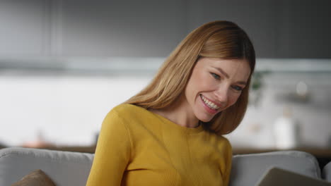 happy woman texting computer at grey sofa closeup. lady freelancer typing email