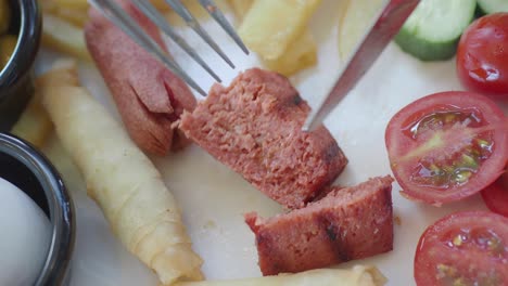 close-up of a delicious turkish breakfast plate with sausage, tomatoes, cucumber, and fries