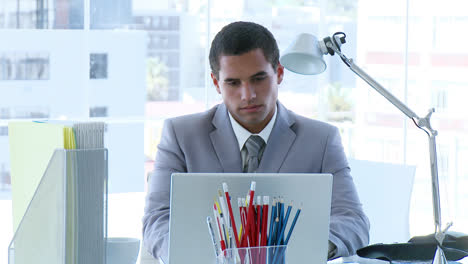 Businessman-working-in-office-and-a-colleague-speaking-to-him