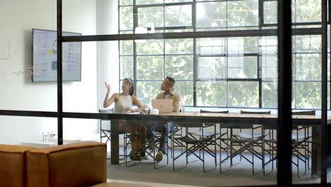 presenting data on screen, business colleagues discussing project in modern office