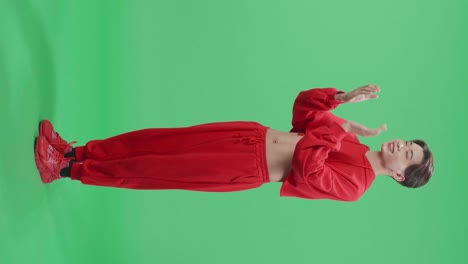 full body of side view of young asian transgender male clapping his hands in the green screen studio