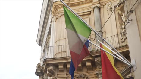 italian and european union flags flying over a building