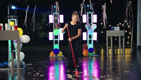 woman sweeping up after an outdoor party