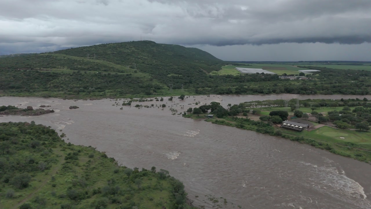 Smooth, cinematic drone footage performing a slow rotation over the confluence of flooding rivers in southern Kruger National Park, near Komatipoort.