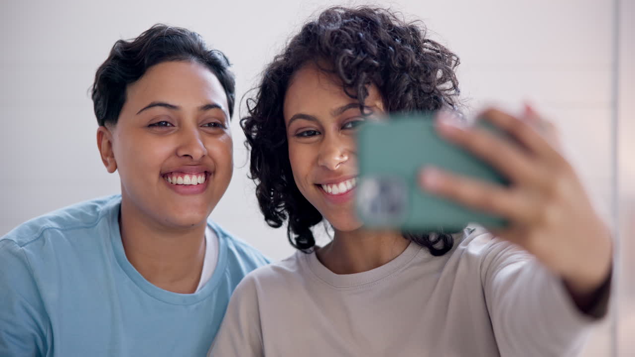 Sorriso, telefono e coppia lesbica a letto in un selfie