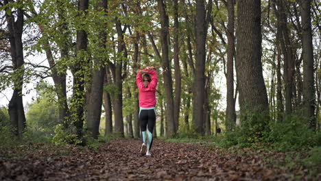 woman stretching in an autumn forest