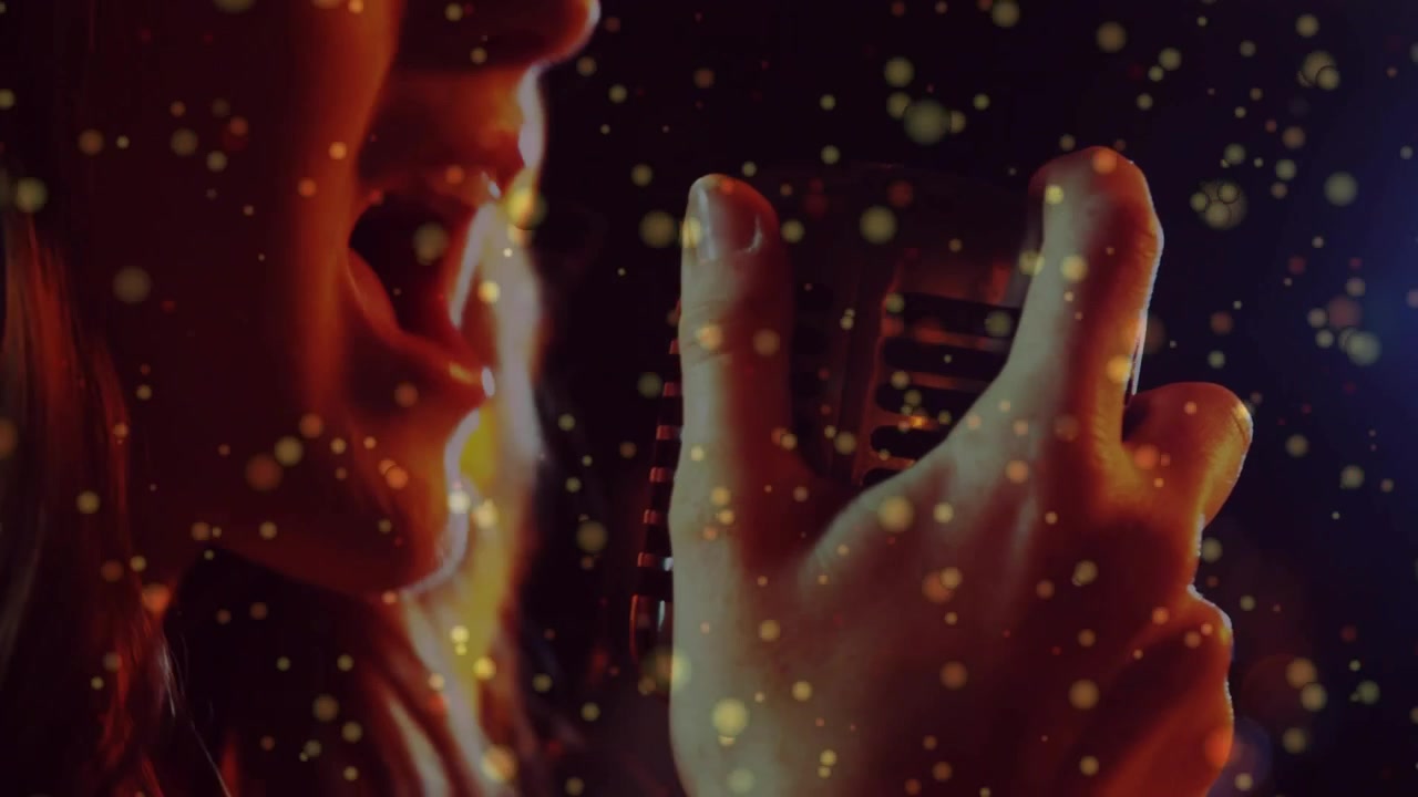 Vocalist starting note, leaning on retro mic, recording, gold bokeh drifting across face and mic