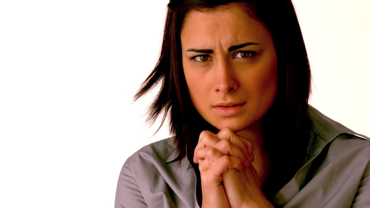 una morena molesta orando a la cámara