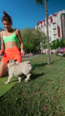 mujer haciendo yoga en el parque con pug