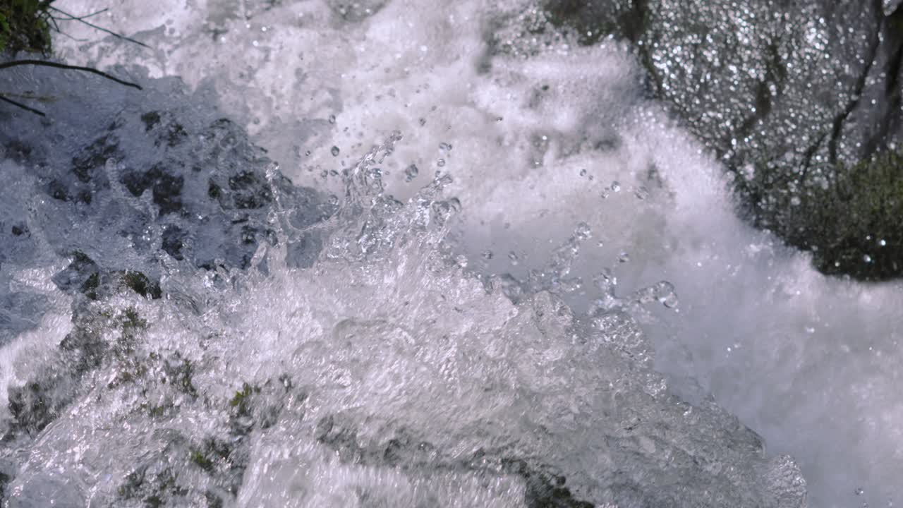 Rough Fresh Clean Waterfall Stream Slow Motion with Water Droplets Cascading Over Edge onto Hard Rocks Below. Natural Environment Footage.