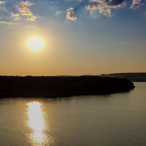 beautiful evening view on the river at sunset. golden path in the water from the setting sun on the natural landscape background. aerial view. motion camera back.