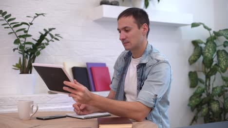 hombre trabajando con tableta en la mesa en casa
