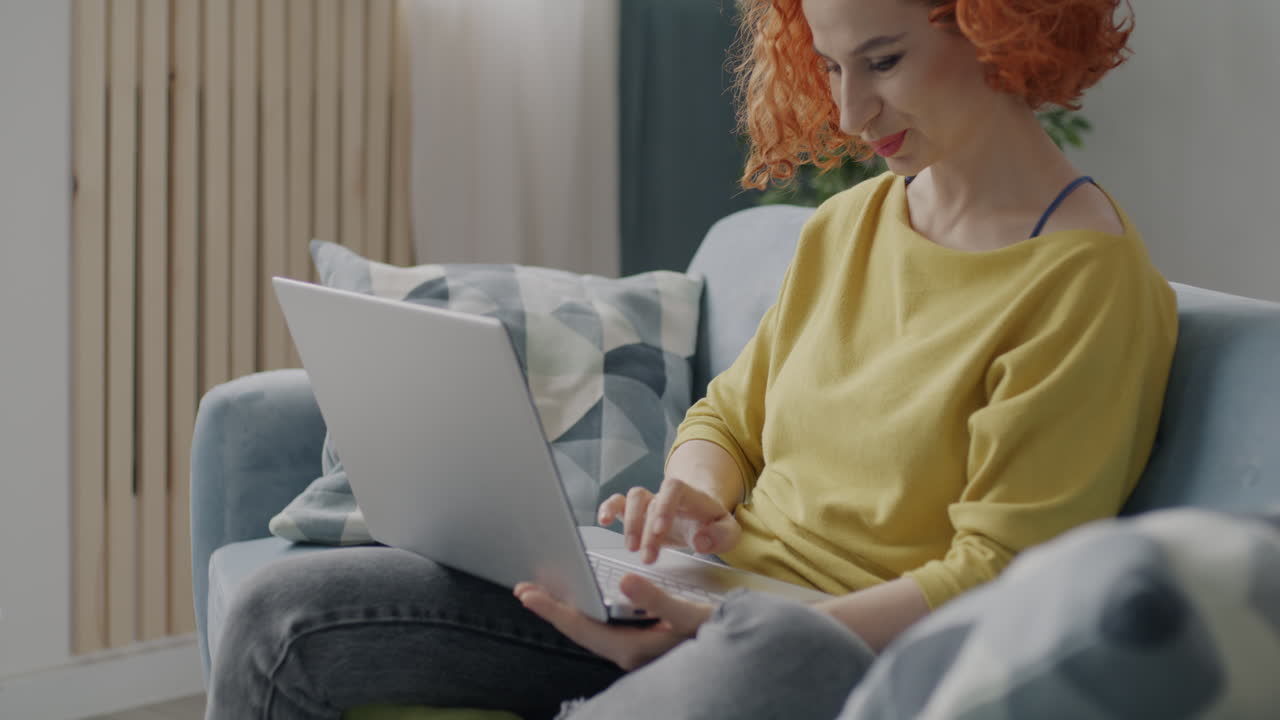 Woman using laptop on a sofa