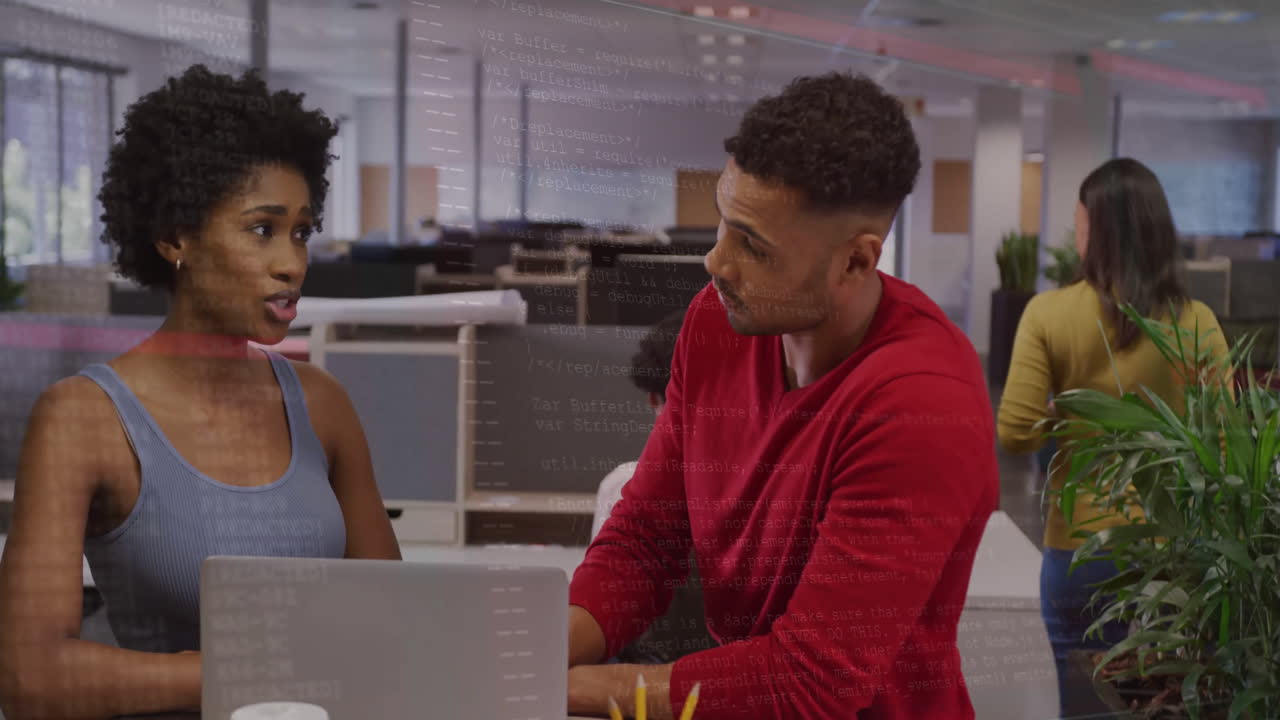 Two colleagues discussing work at office with code animation overlay