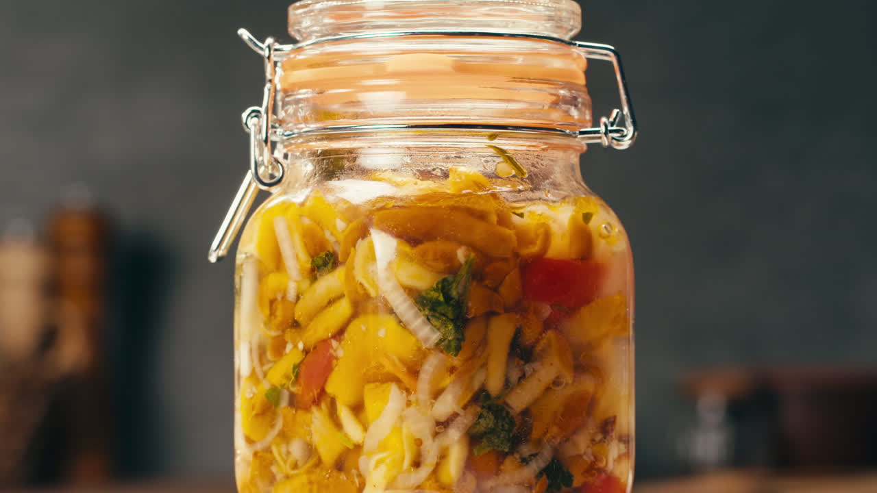 Close-up of fermented yellow honeydew mushrooms with onion in can. Preservation of vegetables in glass jars. Fermentation preserved mushroom with spices.