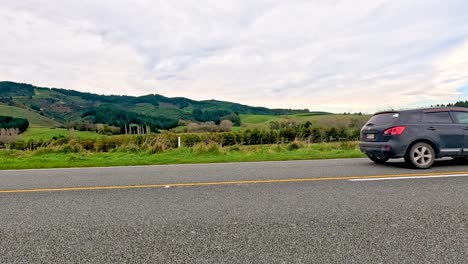 cars drive along a road with bicycles on top, set against lake tekapo's lush landscape under cloudy skies