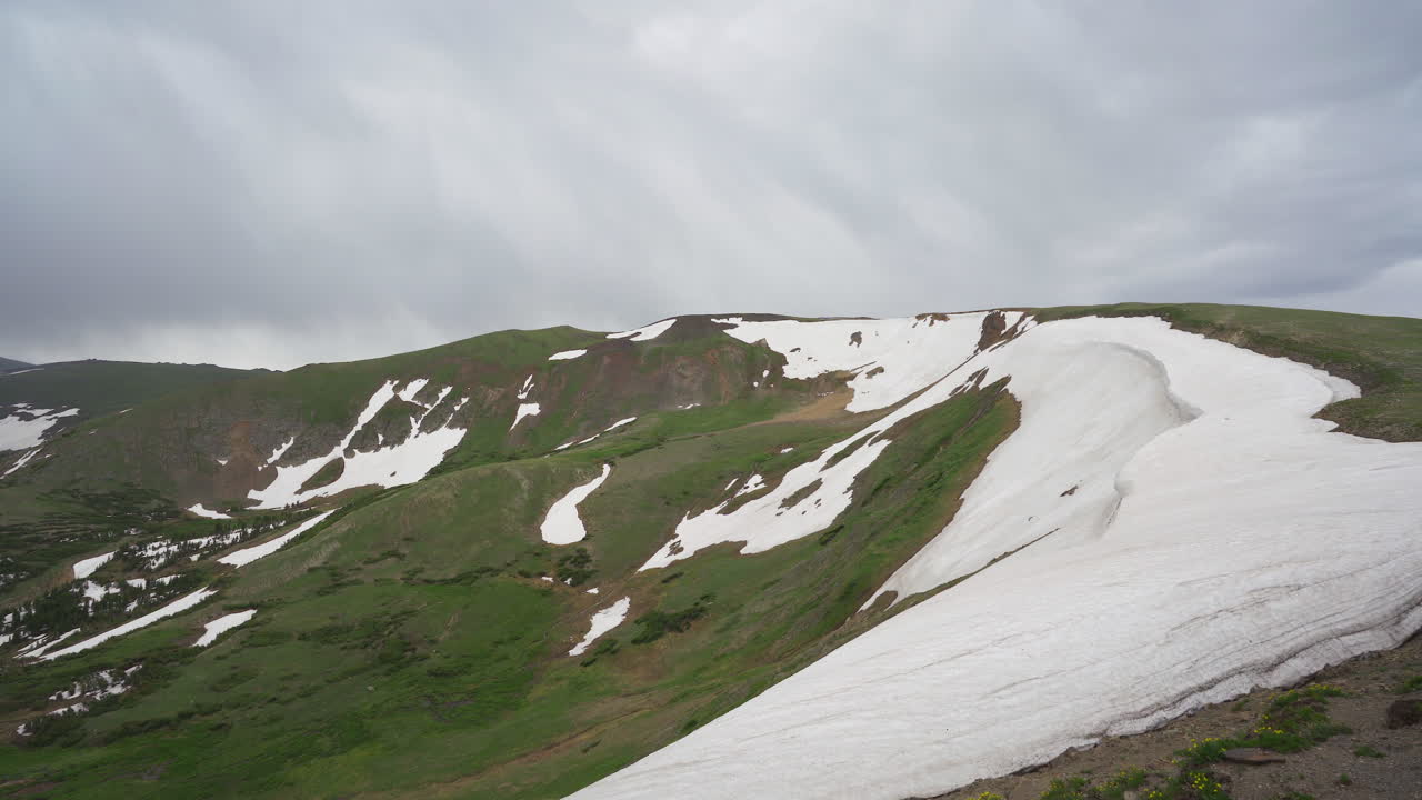 산의 눈 덮인 능선 위에 흐린 하늘