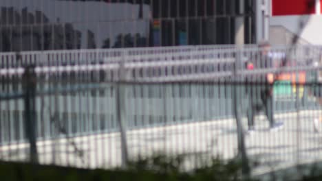 people walking across a bridge in a city