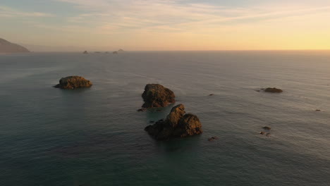 Océano-Prístino-Con-Pilas-De-Mar-En-El-Cielo-Dorado-Del-Atardecer-En-La-Costa-De-Oregon