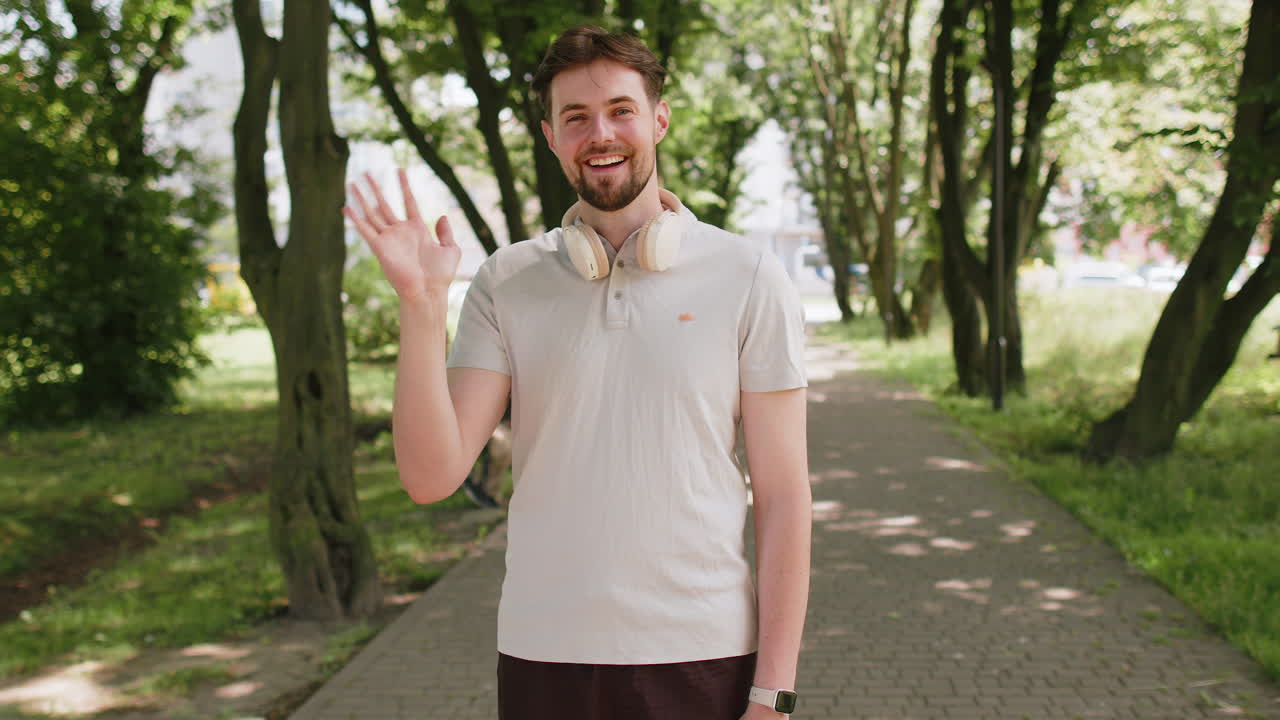 Athletic fit runner guy waving hi hello welcome with palm greeting with hospitable friendly smile