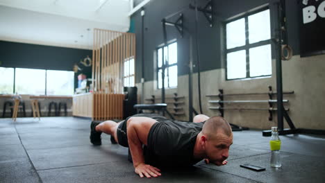 hombre haciendo flexiones en un gimnasio