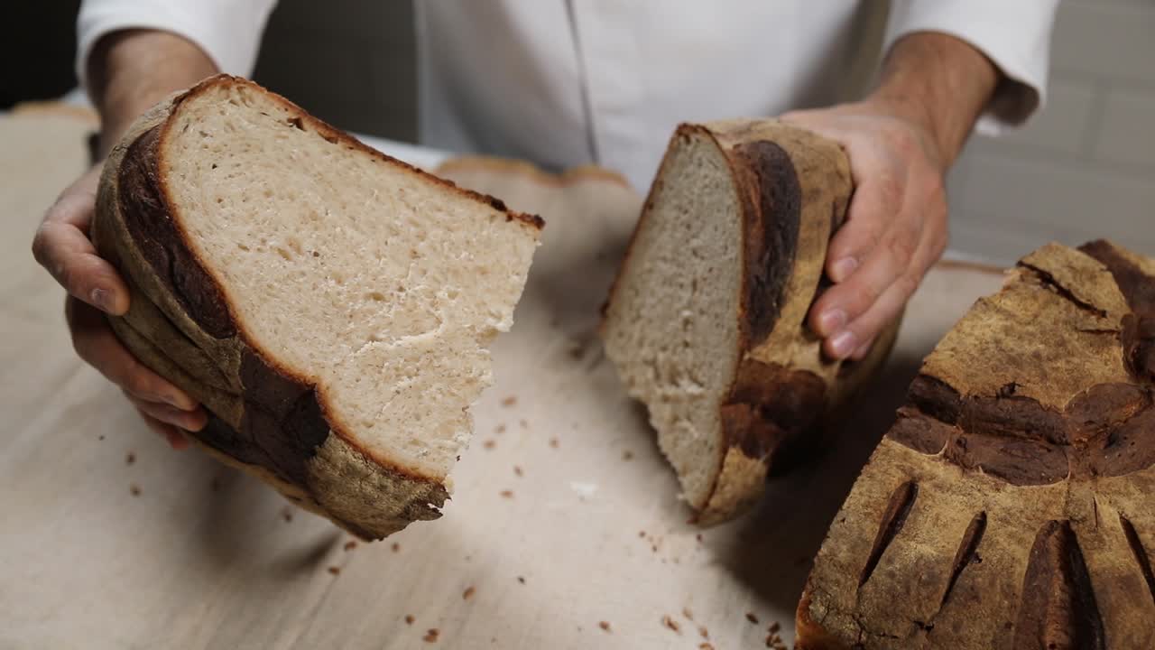 шеф-повар разрезает и держит свежевыпеченный хлеб