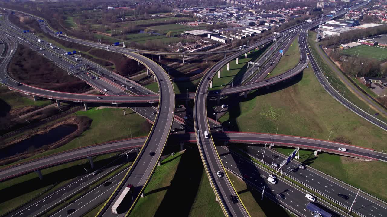 Several highways forming Voorburg junction node passing each other on top and below with traffic moving to all directions. Urban infrastructure in The Netherlands seen from above