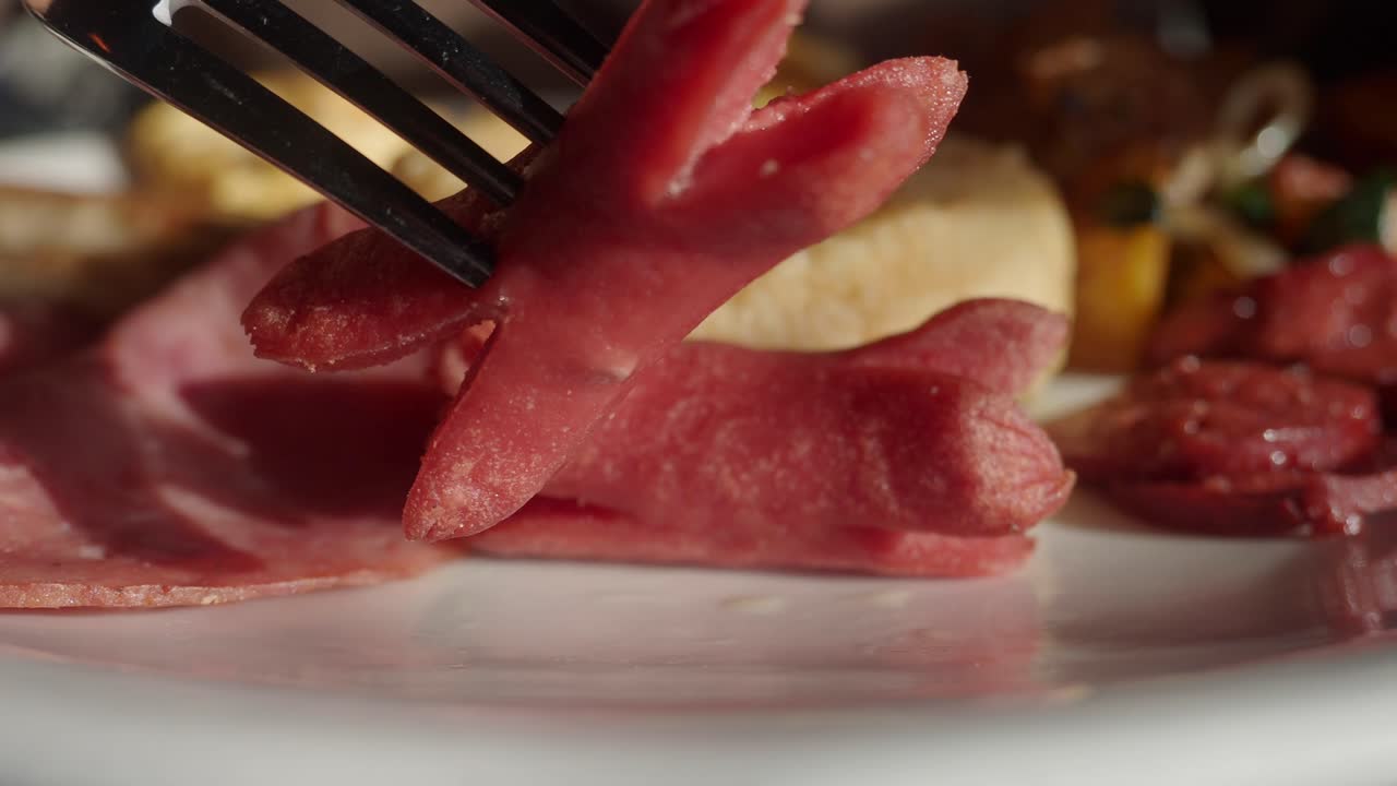 Forchetta che prende una salsiccia a forma di stella da un piatto per la colazione