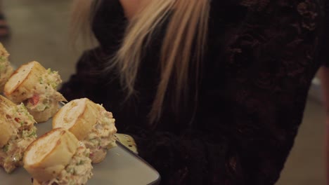 Close-up-shot-of-a-waiter-holding-a-tray-of-canapes-at-a-reception