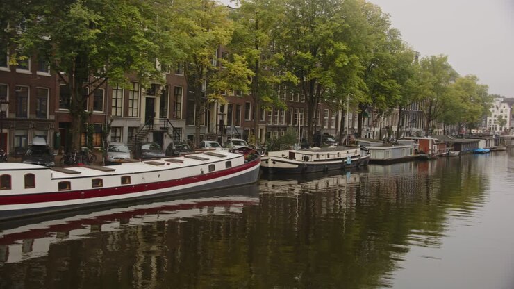 Panoramica su case galleggianti e belle case vicino a un canale ad Amsterdam.