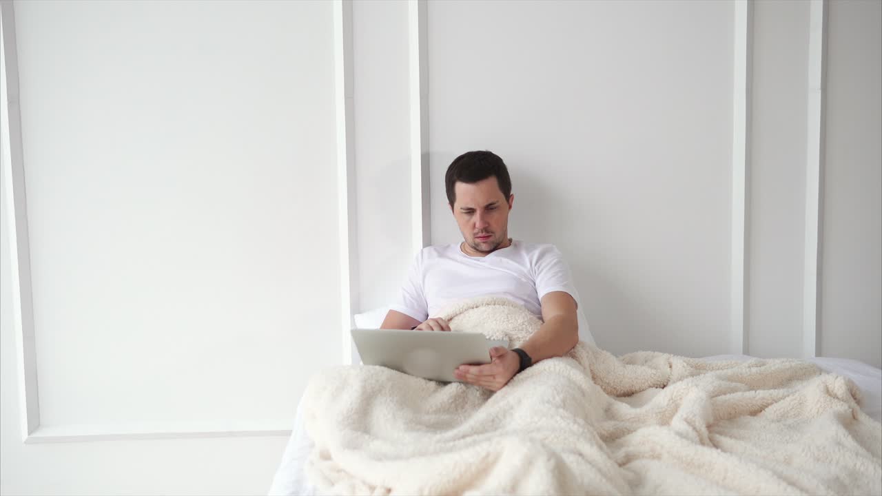 hombre usando tableta en la cama