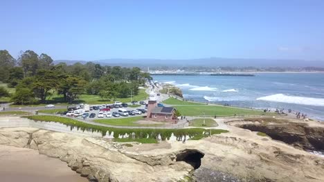 Old-historic-red-brick-lighthouse-on-a-rock-cliff-Dramatic-aerial-view-flight-panorama-overview-drone-footage-of-Santa-Cruz-Beach-Surf-spot-shake-Point-USA-2018-Cinematic-view-above-by-Philipp-Marnitz