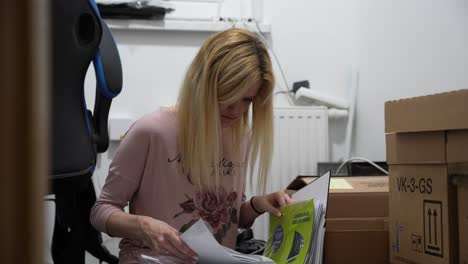 young adult woman leafing a file cabinet before moving out of the apartment