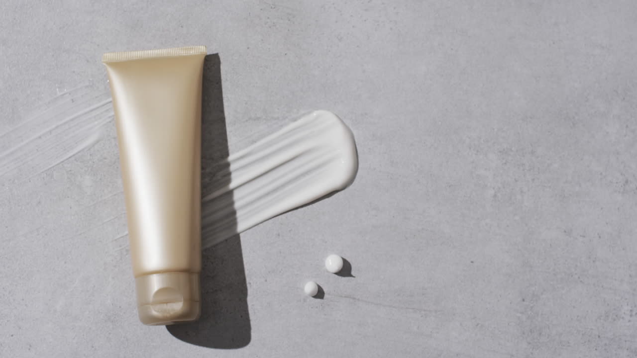 백색 배경에 복사 공간과 함께 미용 제품 튜브 및 크림 얼룩의 비디오