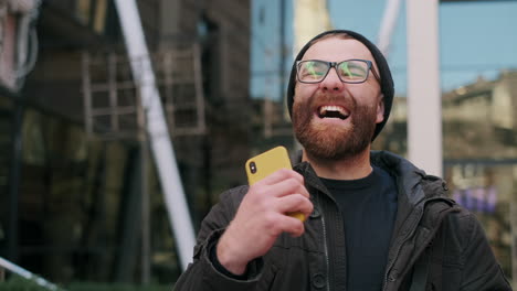 man's expressive reactions while using smartphone