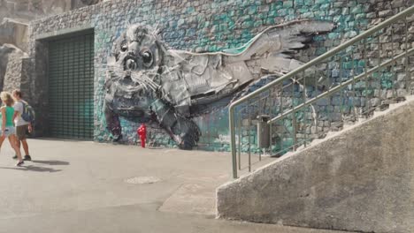 street art mural of a seal with people walking by