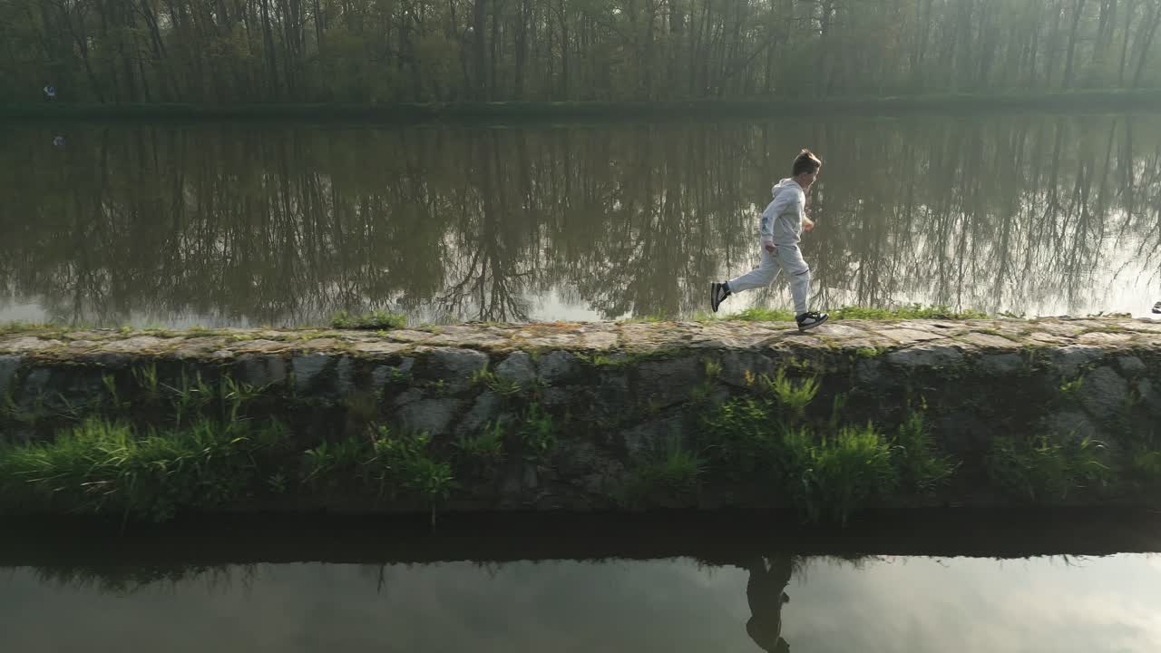 소년과 개가  ⁇ 빛이 빛나는 아침에 안개가 흐르는 강의 돌 기 ?? 에 달리고 있습니다.