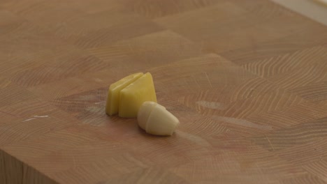 putting-peeled-ginger-on-teh-cutting-board-with-garlic-clove